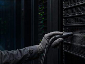 Tecnico con aspiratore ESD davanti alle griglie di un rack attivo